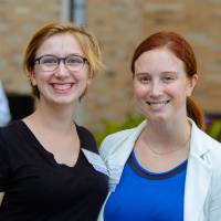 Two guests posing for a photo outside.